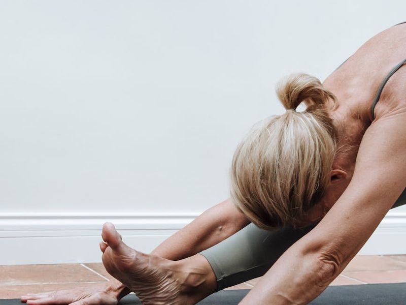 Person doing a focus-oriented yoga movement on a mat.
